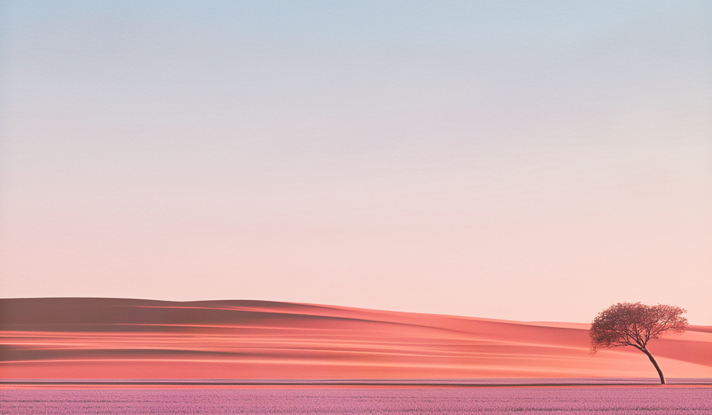 Wind-rippled desert dunes at dusk with a lone acacia tree